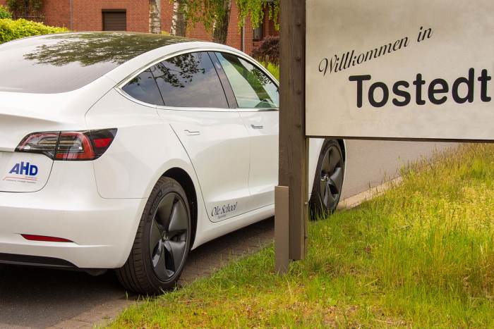 Foto: Tesla steht am Schild "Willkommen in Tostedt"